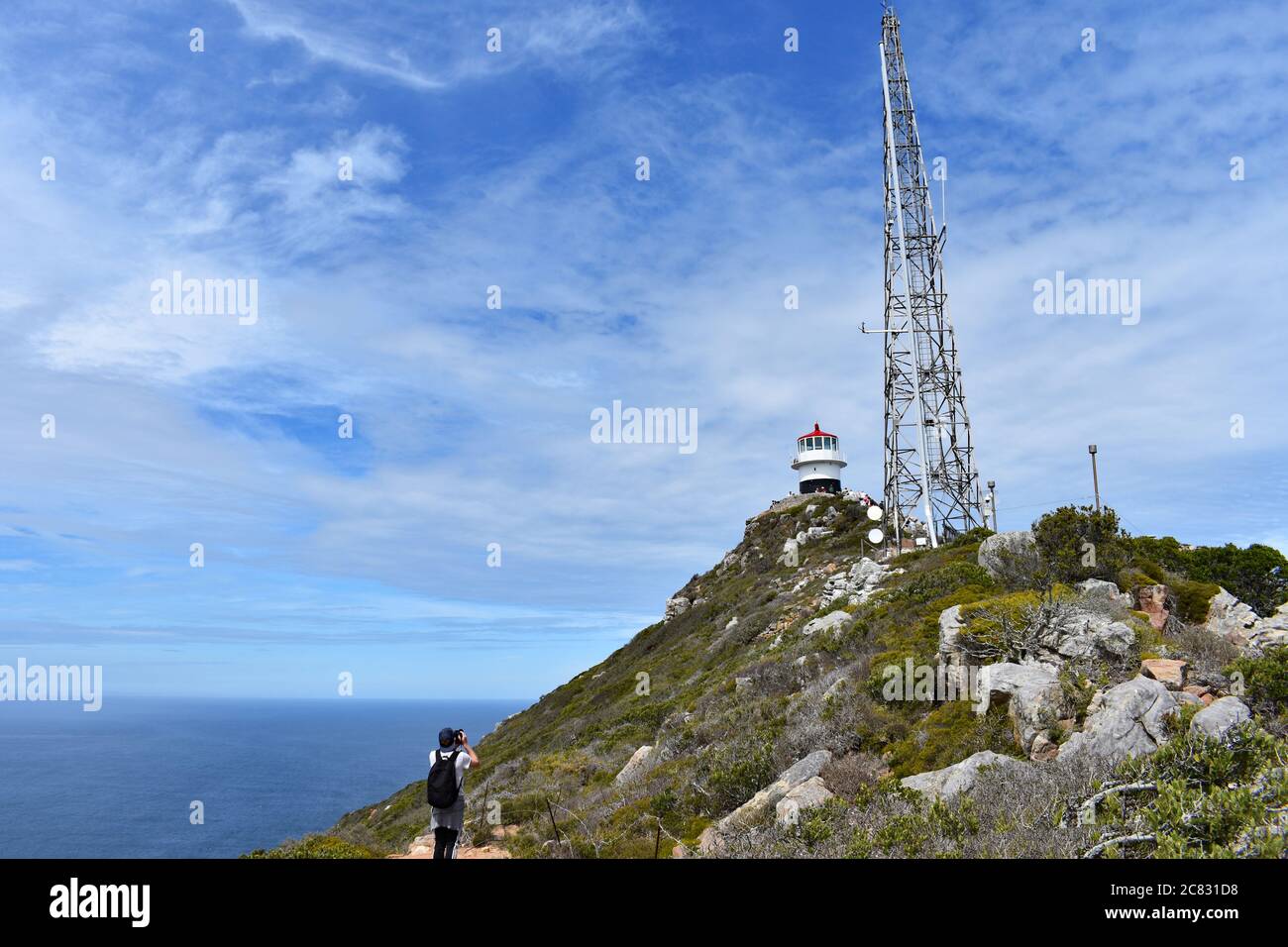 Ein Besucher macht ein Bild vom alten Leuchtturm am Cape Point. Der Atlantische Ozean ist unterhalb des Vorgebirges zu sehen. Kapstadt, Südafrika. Stockfoto