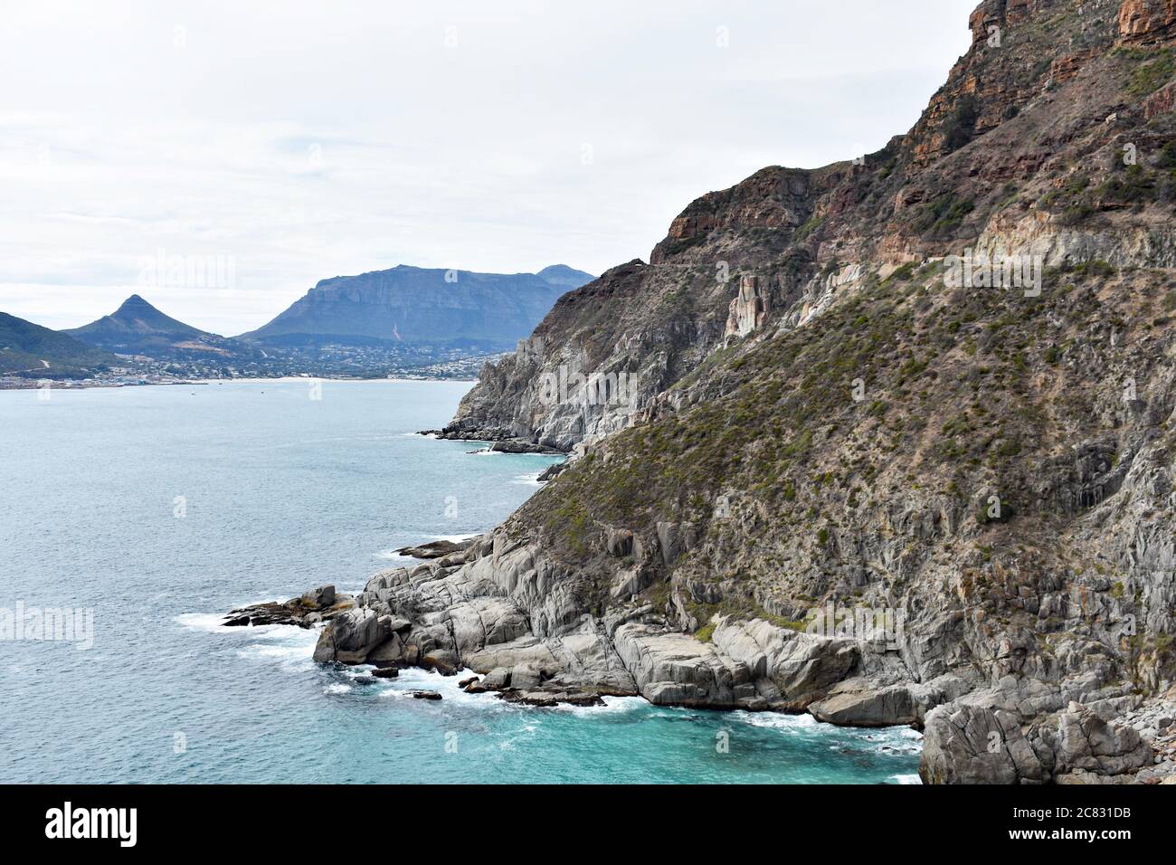 Ein Blick vom Chapmans Peak Drive in Richtung Hout Bay. Der Atlantische Ozean trifft auf die Felswand. Kap-Halbinsel, Südafrika. Stockfoto