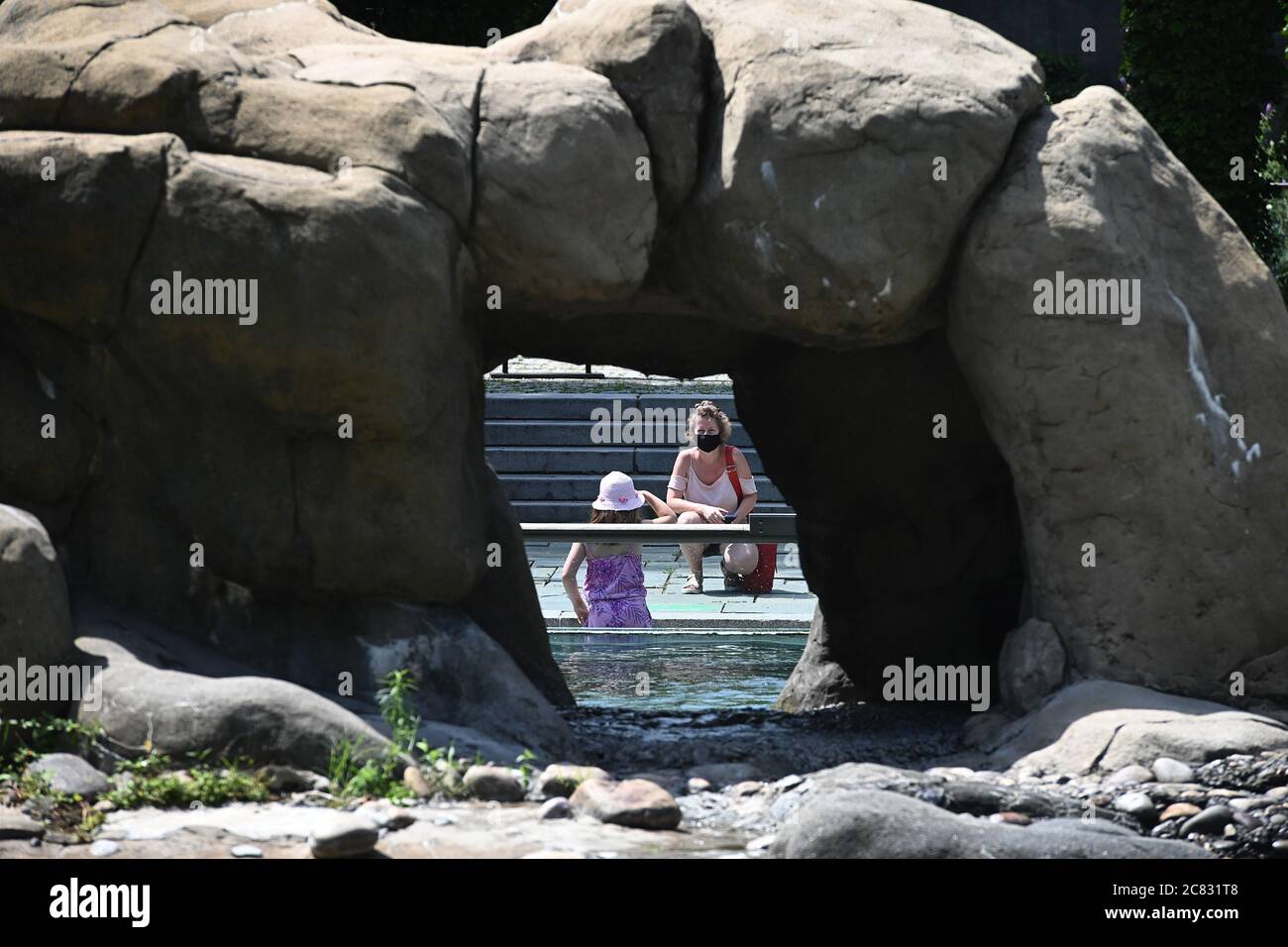 New York City, USA. Juli 2020. Eine Frau wartet auf ein Siegel, das hinter ihrem Kind vorbeikommt, um während ihres Besuchs im Central Park Zoo, der jetzt in Phase 4 der Wiedereröffnung in New York, NY, am 20. Juli 2020 eröffnet wird, Fotos zu machen. In Phase 4 können Zoos botanischen Gärten mit 1/3 Kapazität öffnen, können professionelle Sport ohne Fans und Medienproduktionen mit nicht mehr als 25 Menschen wieder aufnehmen. (Anthony Behar/Sipa USA) Quelle: SIPA USA/Alamy Live News Stockfoto