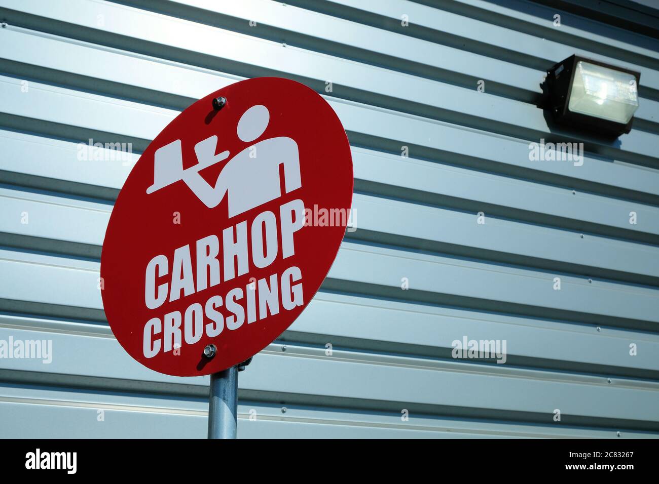 Rotes CarHop-Überkreuzungszeichen mit Symbol eines Servers mit einem Tablett, Getränken und Essen außerhalb eines Antriebs durch an einem Sonic Antrieb im Schnellimbisrestaurant. Stockfoto