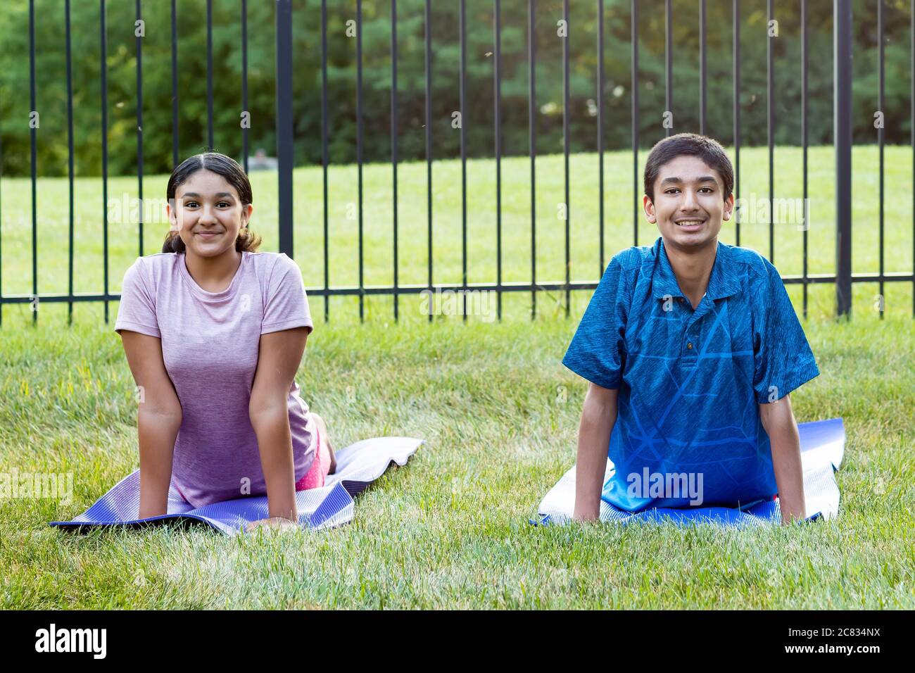 Geschwister üben Yoga im Freien am Morgen Stockfoto