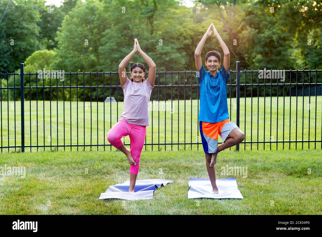 Geschwister üben Yoga im Freien am Morgen Stockfoto