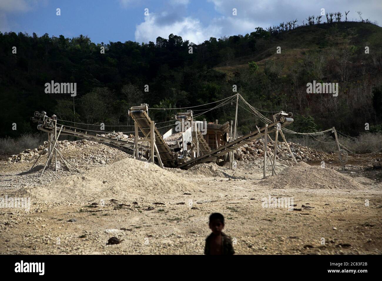 Ein Mineralgewinnungsgebiet im Vordergrund eines Kindes am Stadtrand von Waikabubak, West Sumba, Ost-Nusa Tenggara, Indonesien. Stockfoto