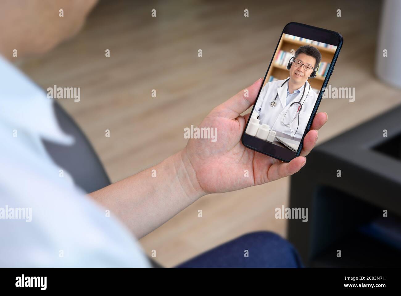 Ein asiatischer Arzt, der sich mit einem Patienten ferngesteuert berät. TeleheHealth-Konzept Stockfoto