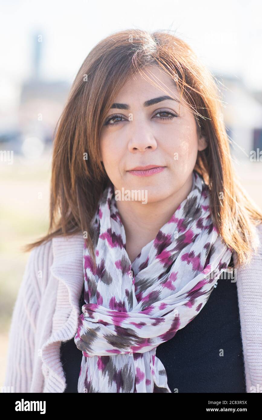 40 Jahre alte Frau, die im Freien auf die Kamera schaut Stockfoto