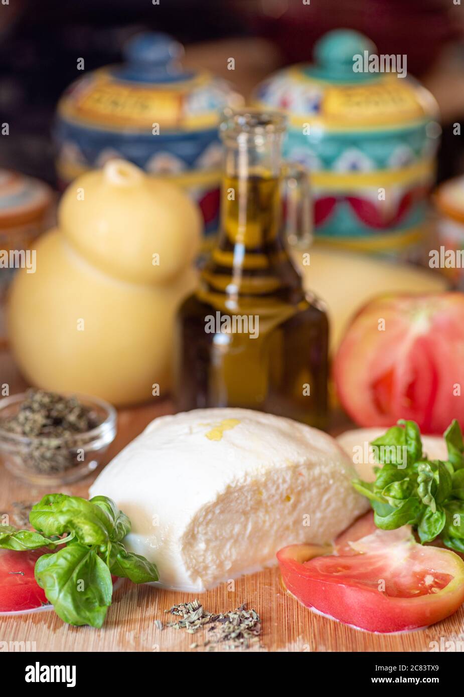 Neapel, Italien. Mozzarella-Käse, Basilikum und Tomatenscheiben auf dem Chopper-Brett mit Olivenöl und einem Scamorza-Käse. Zutaten für Caprese Salat. Stockfoto