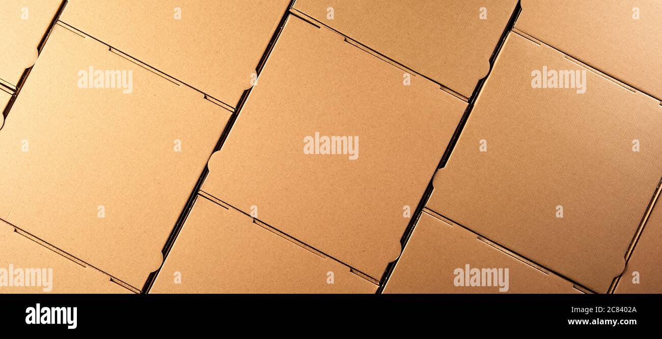 Panorama-Banner mit unbeschrifteten neuen recycelbaren braunen Karton Pizzakartons symmetrisch in einer Schicht für eine Vollformat-Hintergrundstruktur verpackt Stockfoto