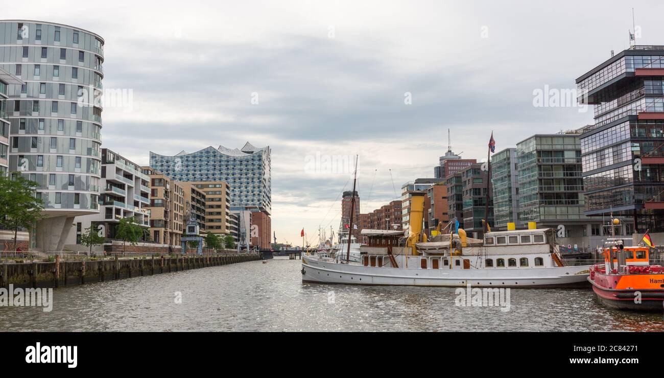 Blick entlang des Sandtorhafens in Richtung Elbphilharmonie. Stadtbild der Hamburger HafenCity mit modernen Gebäuden und Booten. Stockfoto