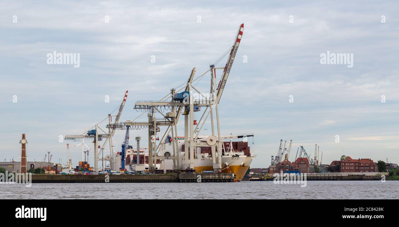 Container Terminal mit mehreren Hafenkranen und einem Containerschiff. Symbol für Handel, Logistik und Wirtschaft. Stockfoto