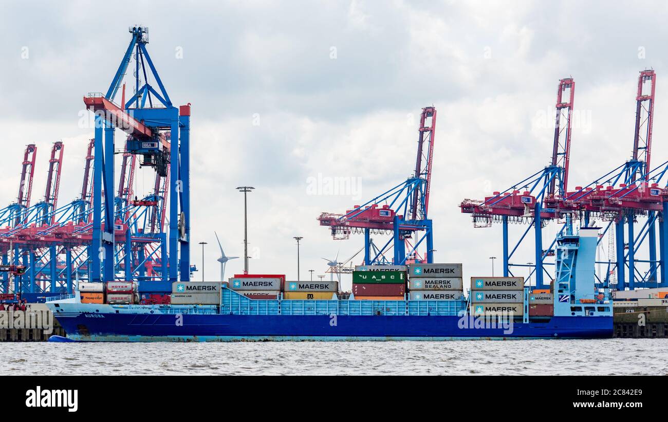 Seitenansicht eines Containerschiffes, das an einem Containerterminal im Hamburger Hafen ankern soll. Ladedock mit Kränen. Stockfoto