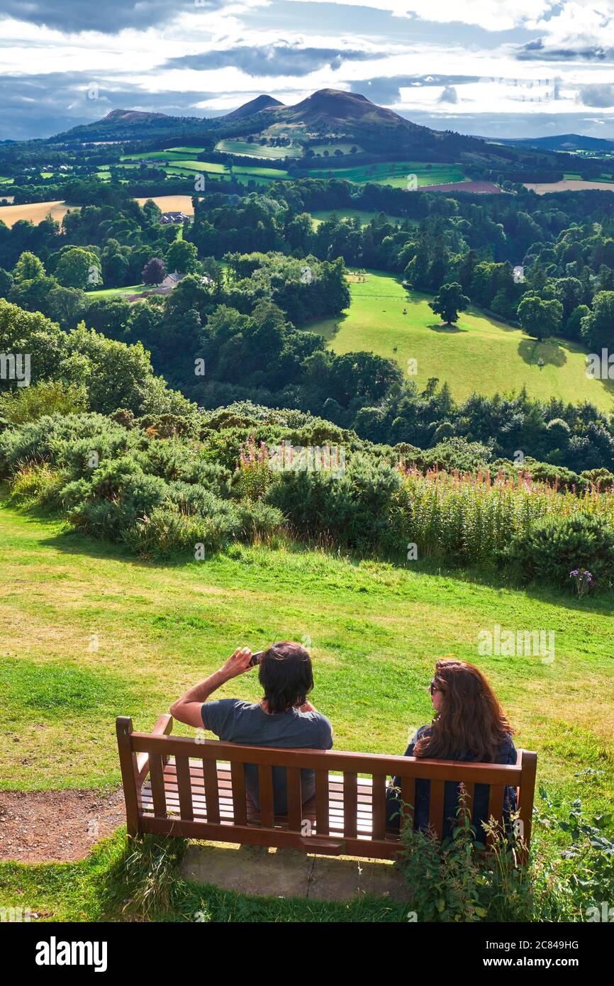 Paar sitzen auf Holzbank genießen die Panorama-aussicht bekannt Als 'Scott's View' am Bemersyde Hill in der Nähe von Melrose in der Scottish Borders Stockfoto