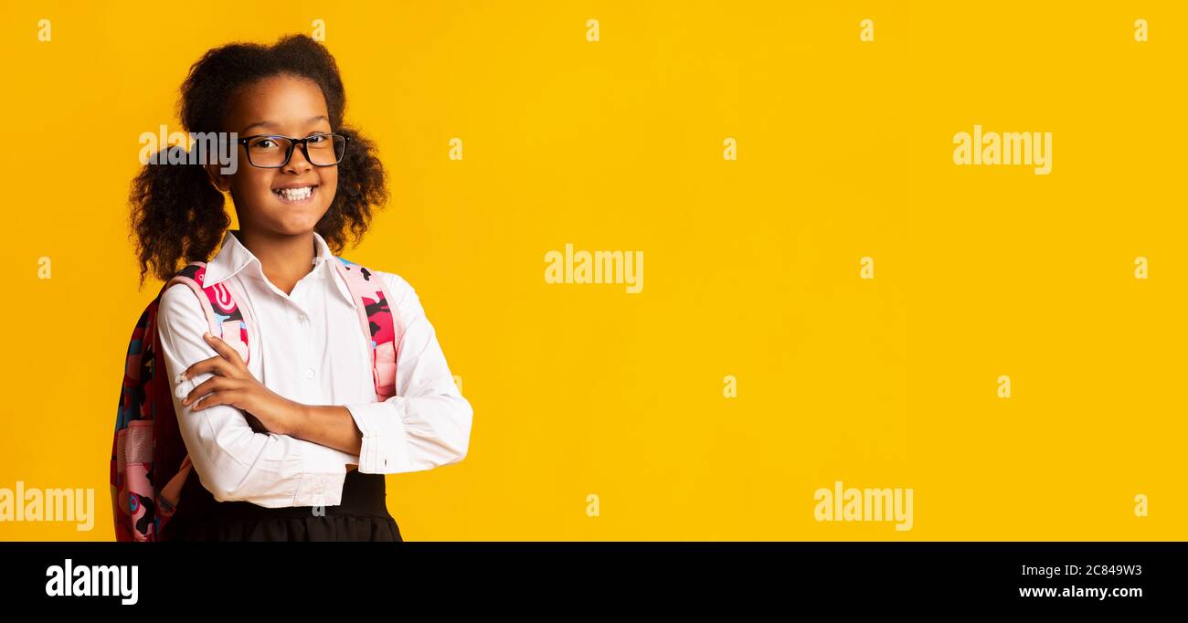 Glücklich Schulmädchen Crossing Hände Lächelnd Posiert Auf Gelbem Hintergrund, Panorama Stockfoto