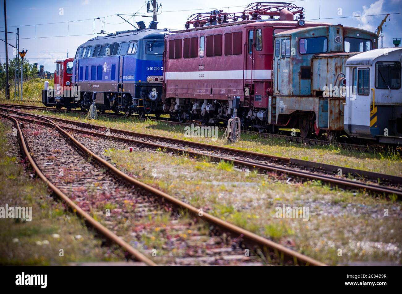 16. Juli 2020, Mecklenburg-Vorpommern, Mukran: Alte Lokomotiven und Waggons stehen auf dem Freigelände vor der Reparaturwerkstatt der Baltic Port Services GmbH (BPS). In der Werkstatt, die 1986 von der Deutschen Reichsbahn eröffnet wurde, wurden Schienenfahrzeuge, die von der Eisenbahnfähre kommen, von der 1520 Millimeter breiten russischen Breitspur auf die im übrigen Europa übliche Standardspur umgemessen. Die Werkstatt, die 2014 von der heutigen Firma Enon mit Sitz in Putlitz, Brandenburg, übernommen wurde, saniert alte Lokomotiven und Eisenbahnwaggons für den Einsatz durch private Bahnunternehmen. Pho Stockfoto