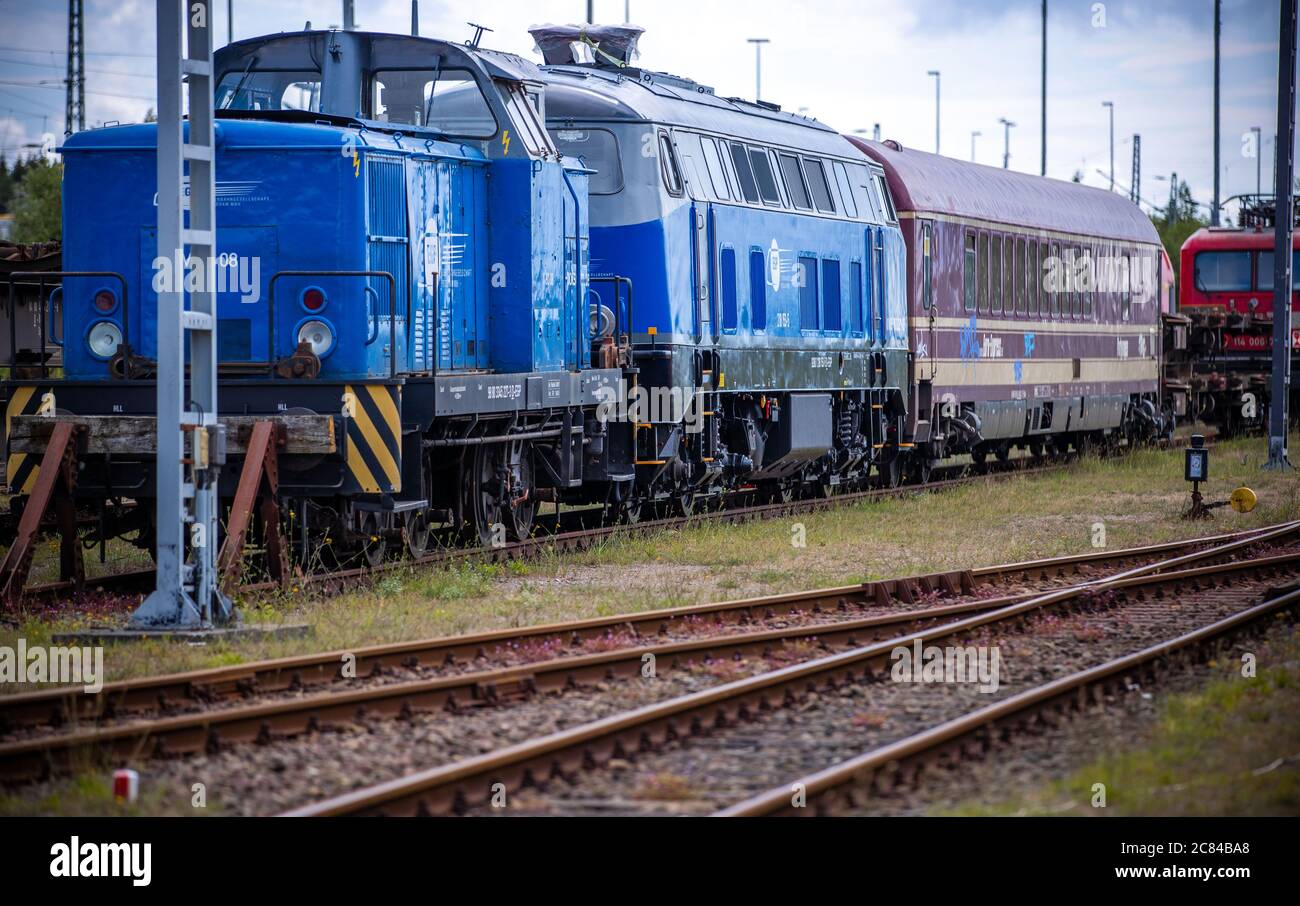 16. Juli 2020, Mecklenburg-Vorpommern, Mukran: Alte Lokomotiven und Waggons stehen auf dem Freigelände vor der Reparaturwerkstatt der Baltic Port Services GmbH (BPS). In der Werkstatt, die 1986 von der Deutschen Reichsbahn eröffnet wurde, wurden Schienenfahrzeuge, die von der Eisenbahnfähre kommen, von der 1520 Millimeter breiten russischen Breitspur auf die im übrigen Europa übliche Standardspur umgemessen. Die Werkstatt, die 2014 von der heutigen Firma Enon mit Sitz in Putlitz, Brandenburg, übernommen wurde, saniert alte Lokomotiven und Eisenbahnwaggons für den Einsatz durch private Bahnunternehmen. P Stockfoto