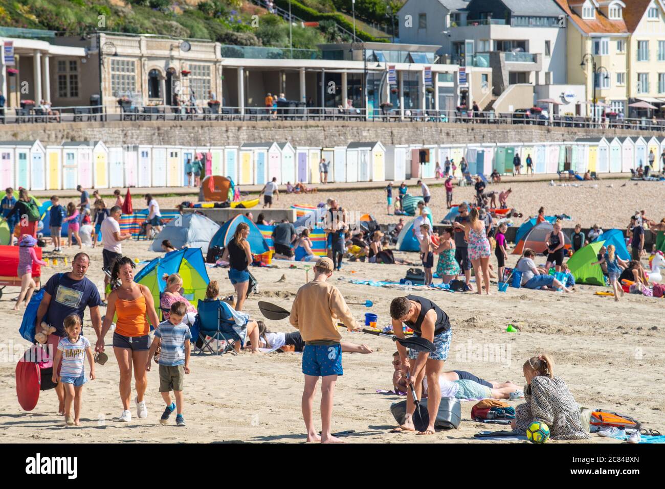 Lyme Regis, Dorset, Großbritannien. Juli 2020. Wetter in Großbritannien: Urlauber gehen an den Strand von Lyme Regis, um einen weiteren Tag mit heißer Sonne und strahlend blauem Himmel zu genießen. Heute werden wieder Menschenmengen erwartet, da die Temperaturen in Südengland weiter steigen. Kredit: Celia McMahon/Alamy Live Nachrichten Stockfoto