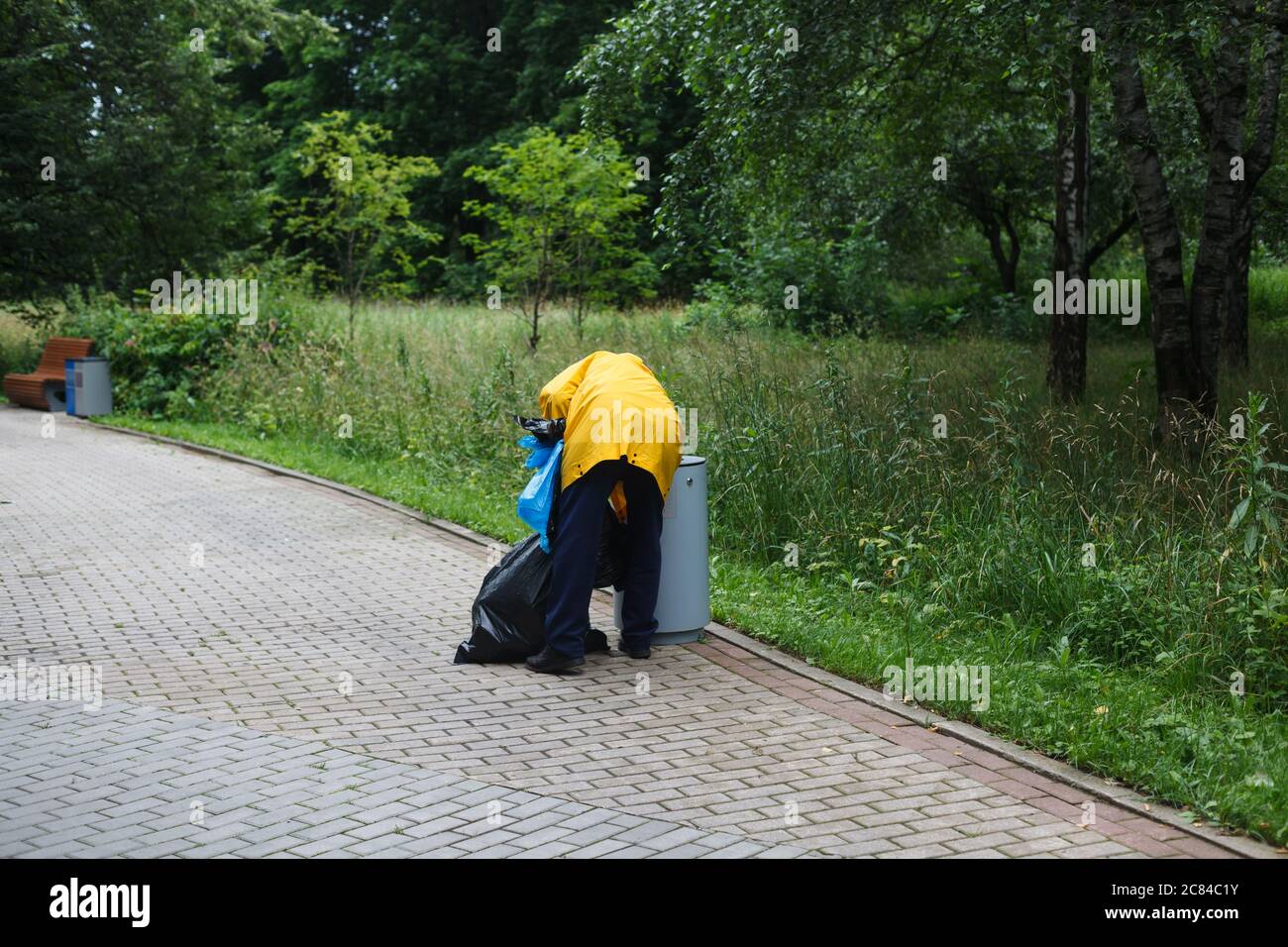 Mann, der Müll im öffentlichen Park sortiert. Müllabfuhr Stockfoto