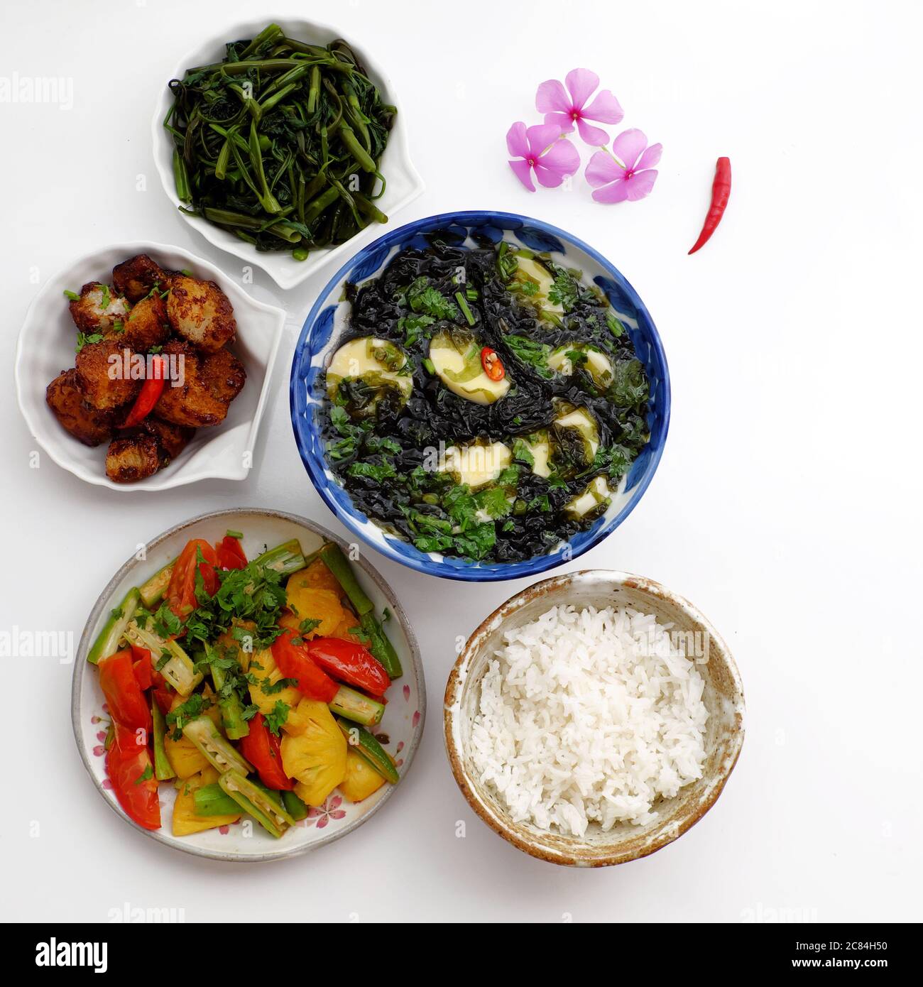 Vietnamesische vegane Küche, tägliches Familienessen zum Mittagessen, Abendessen, Algensuppe, Tofu, gebratenes Gemüse, getrocknetes Brot kochen mit Sauce, gekochtes Wasser Spinat Stockfoto