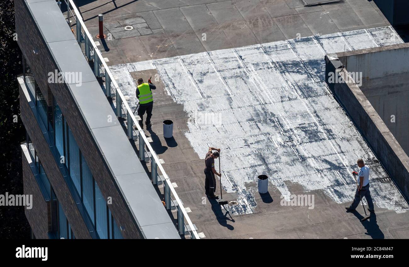 Vogelperspektive auf eine Dachbaustelle. Professionelle Bitumen-Abdichtung auf einem flachen Gebäude. Stockfoto