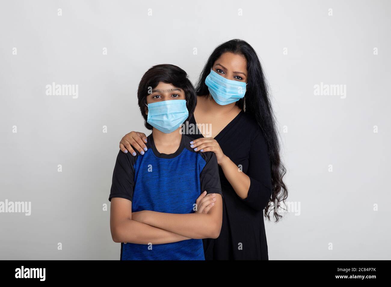 Indische Mutter und Sohn tragen Covid Schutzmaske, Frau und kleiner Junge stehen zusammen mit Gesichtsmaske Stockfoto