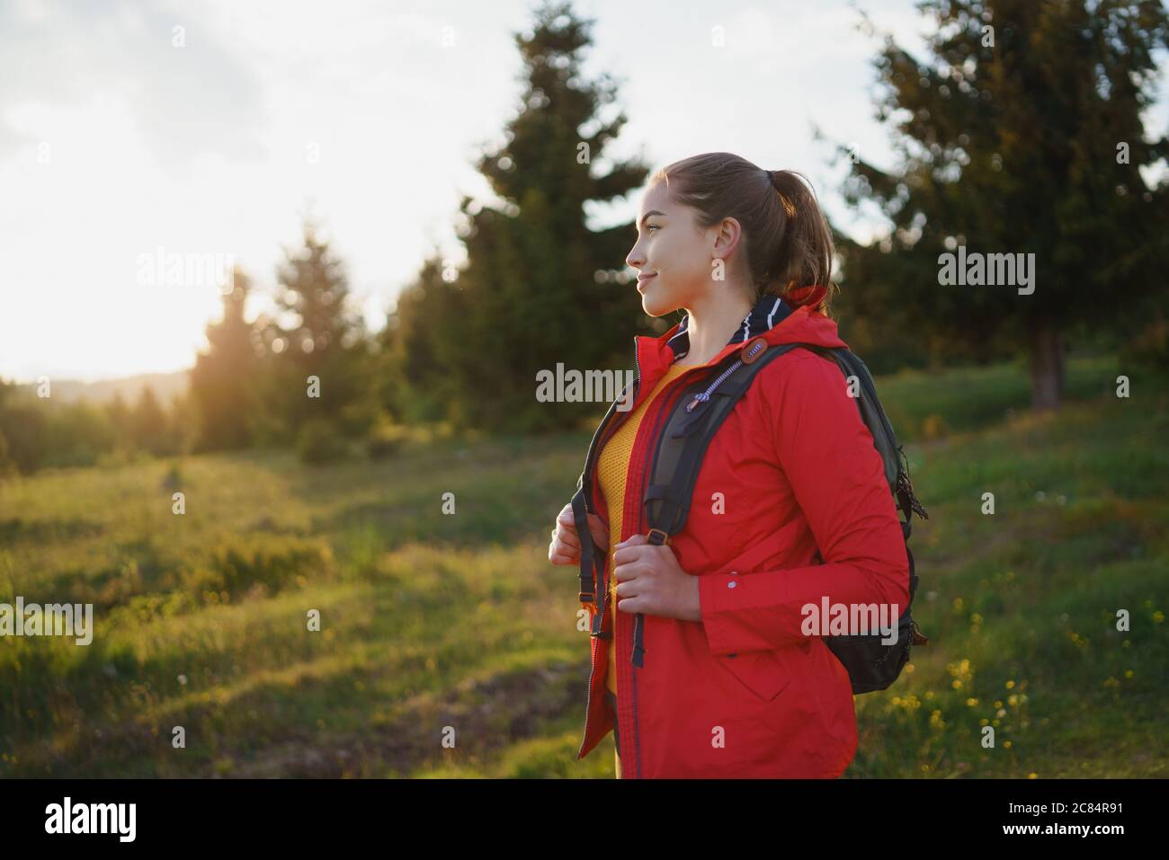 Junge Frau auf einem Spaziergang im Freien auf der Wiese im Sommer Natur, Wandern. Stockfoto