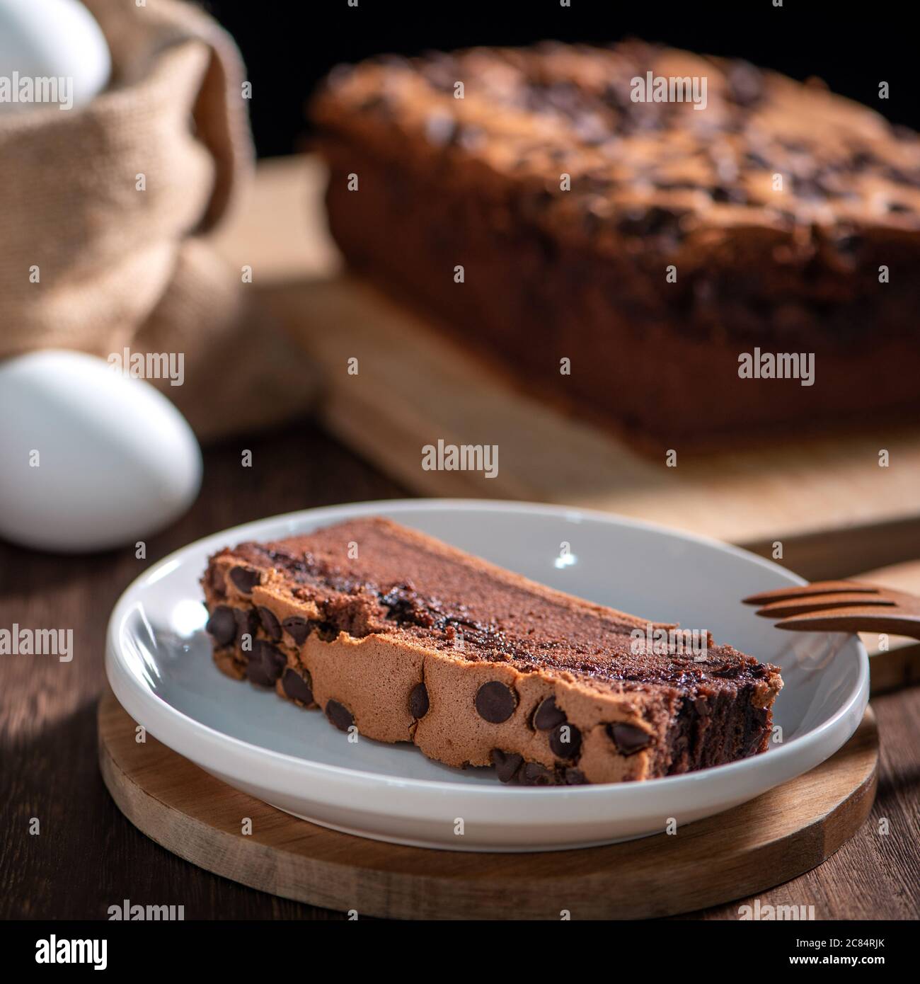 Schokoladengeschmack taiwanesische traditionelle Biskuitkuchen (taiwanesische castella kasutera) auf einem Holztablett Hintergrund Tisch mit Zutaten, close up. Stockfoto