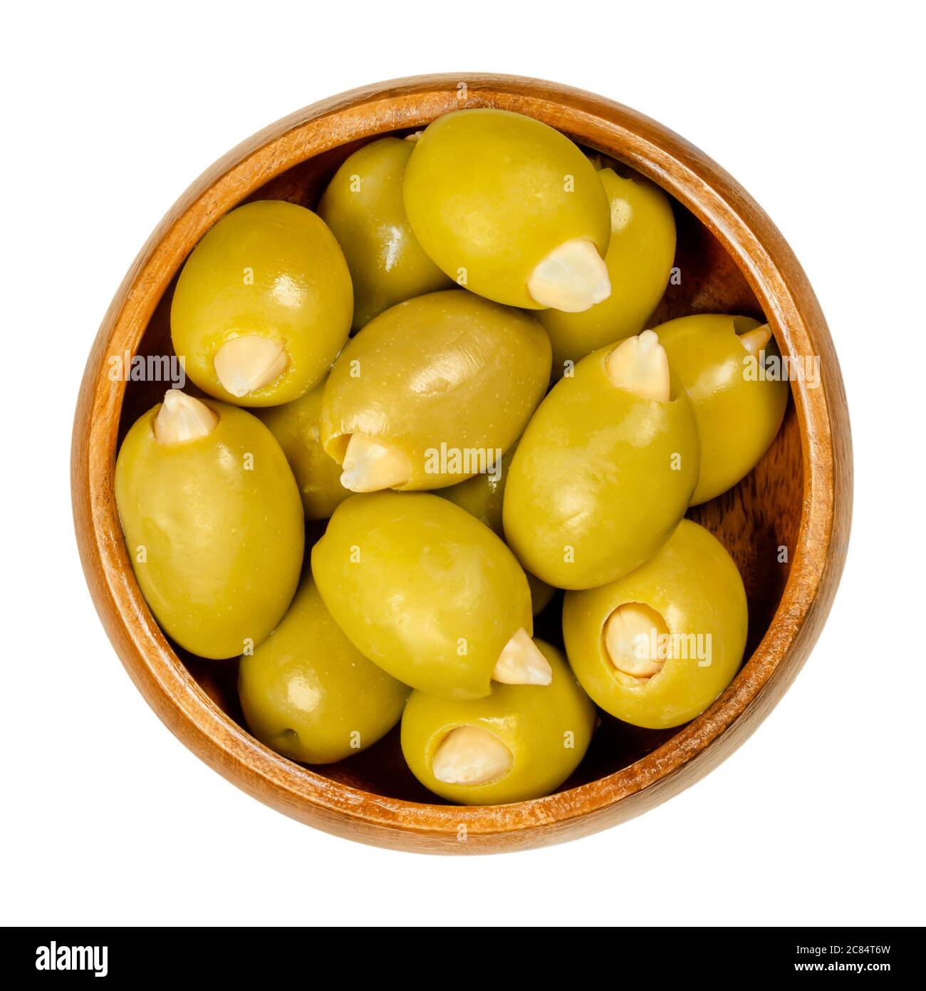 Mandel gefüllte grüne Oliven in Holzschüssel. Große europäische Oliven, Früchte von Olea europaea, handgefüllt mit eingelegten knackigen Mandeln. Stockfoto