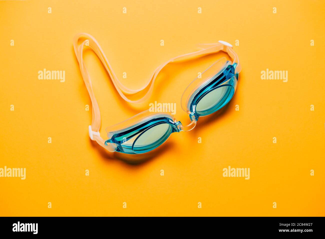Blaue Schwimmbrille, mit Gummiband auf gelbem Hintergrund. Niemand, Produktkonzept Stockfoto