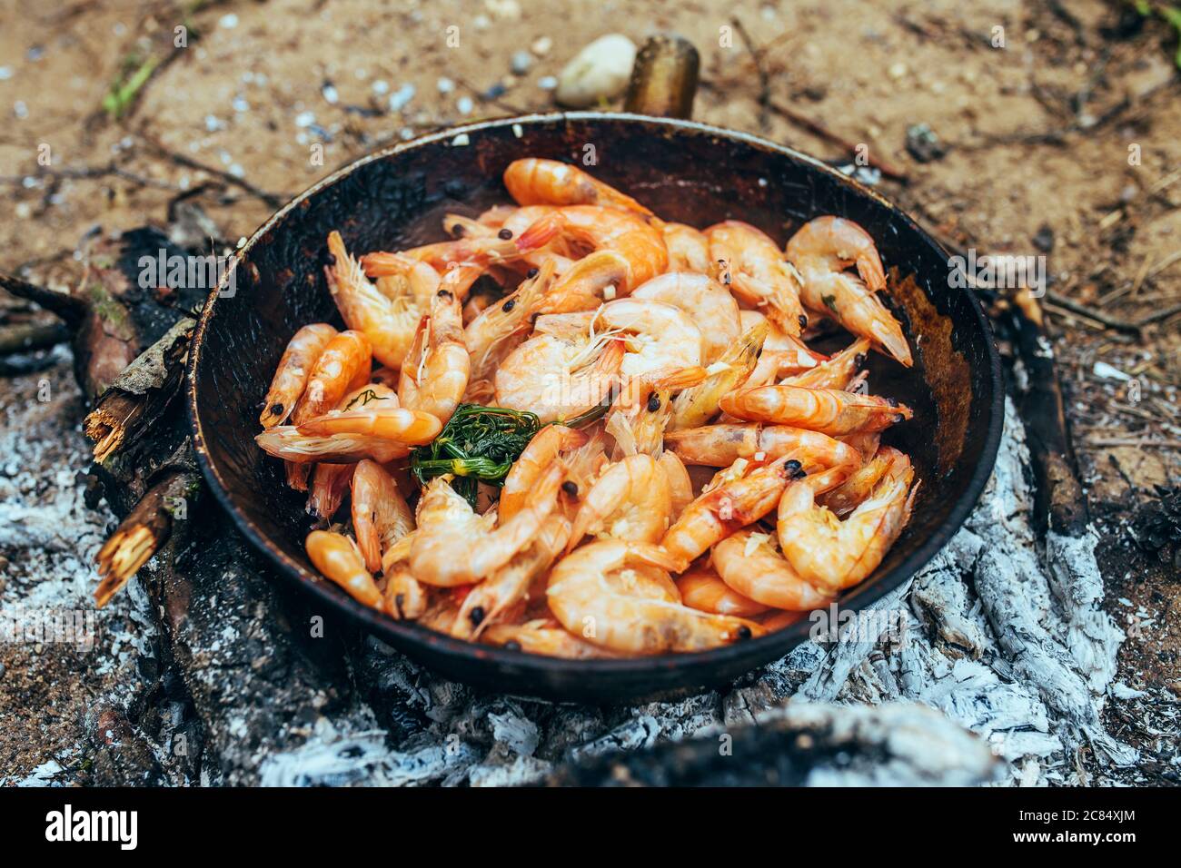 Heiße Garnelen in kochendem Öl in einer Pfanne - gegrillte Meeresfrüchte Stockfoto