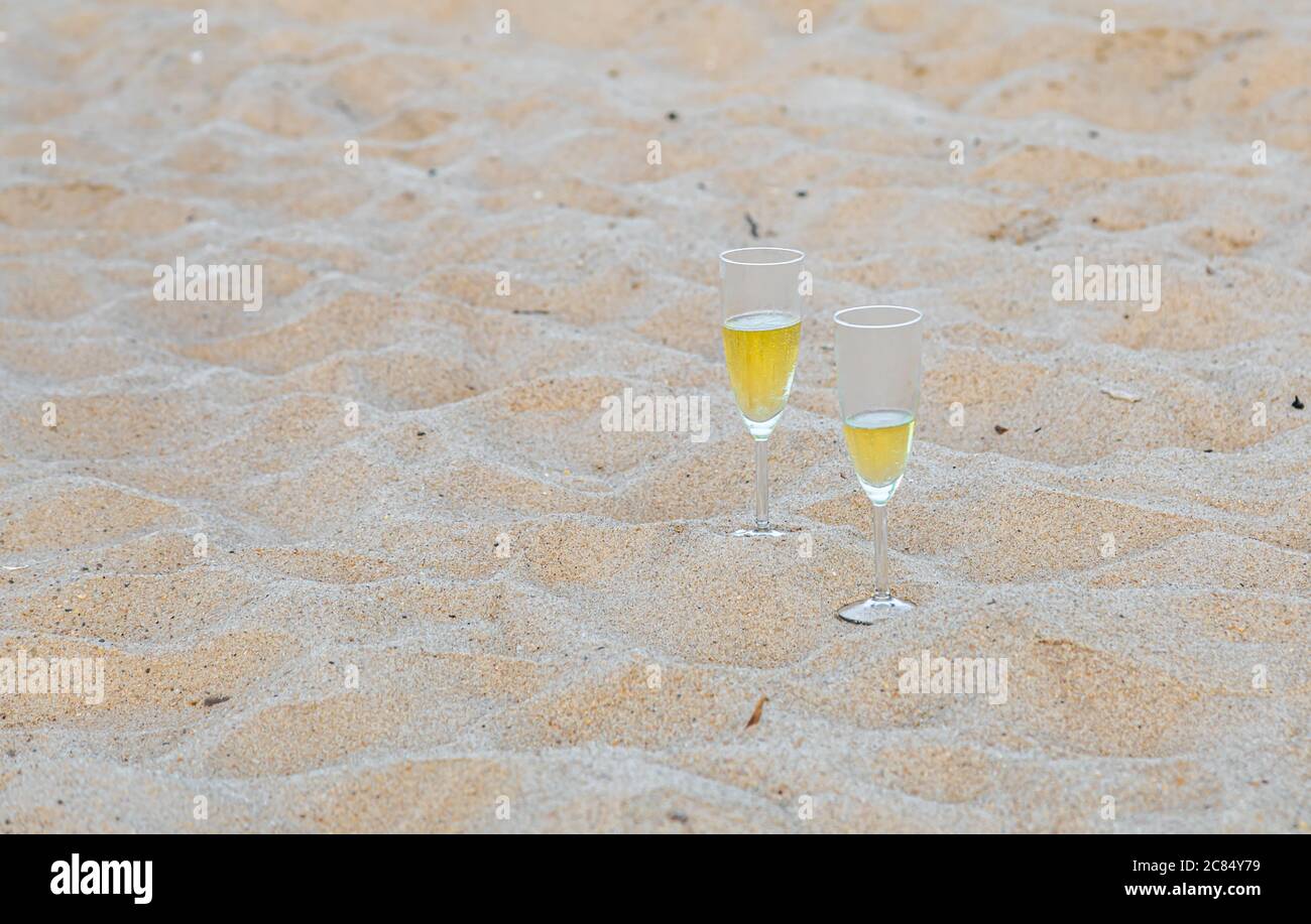 Zwei Sektgläser, die im Sand an einem Meeresstrand in Amagansett, NY, sitzen Stockfoto