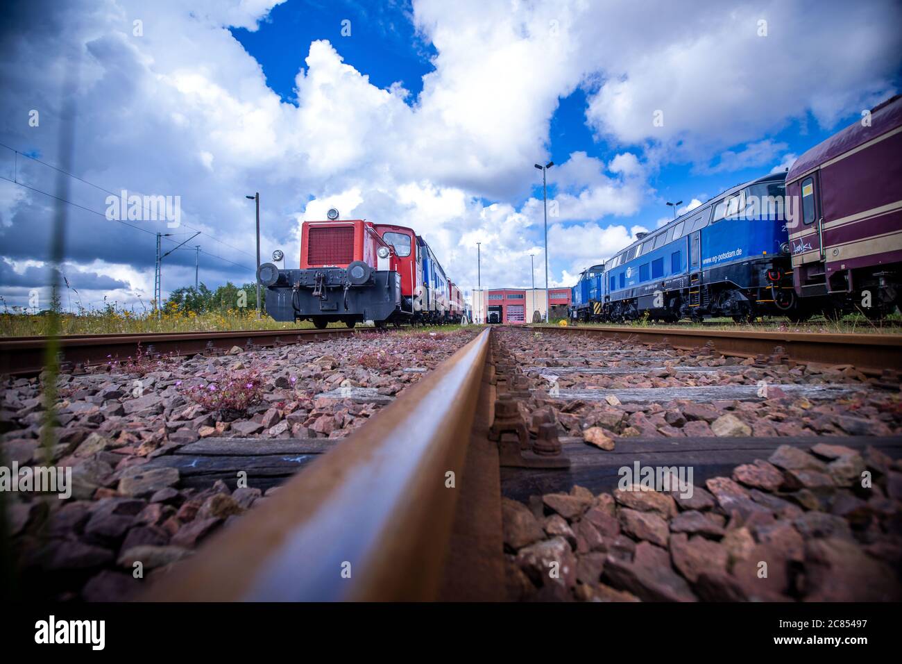 16. Juli 2020, Mecklenburg-Vorpommern, Mukran: Alte Lokomotiven und Waggons stehen auf dem Freigelände vor der Reparaturwerkstatt der Baltic Port Services GmbH (BPS). In der Werkstatt, die 1986 von der Deutschen Reichsbahn eröffnet wurde, wurden Schienenfahrzeuge, die von der Eisenbahnfähre kommen, von der 1520 Millimeter breiten russischen Breitspur auf die im übrigen Europa übliche Standardspur umgemessen. Die Werkstatt, die 2014 von der heutigen Firma Enon mit Sitz in Putlitz, Brandenburg, übernommen wurde, saniert alte Lokomotiven und Eisenbahnwaggons für den Einsatz durch private Bahnunternehmen. P Stockfoto