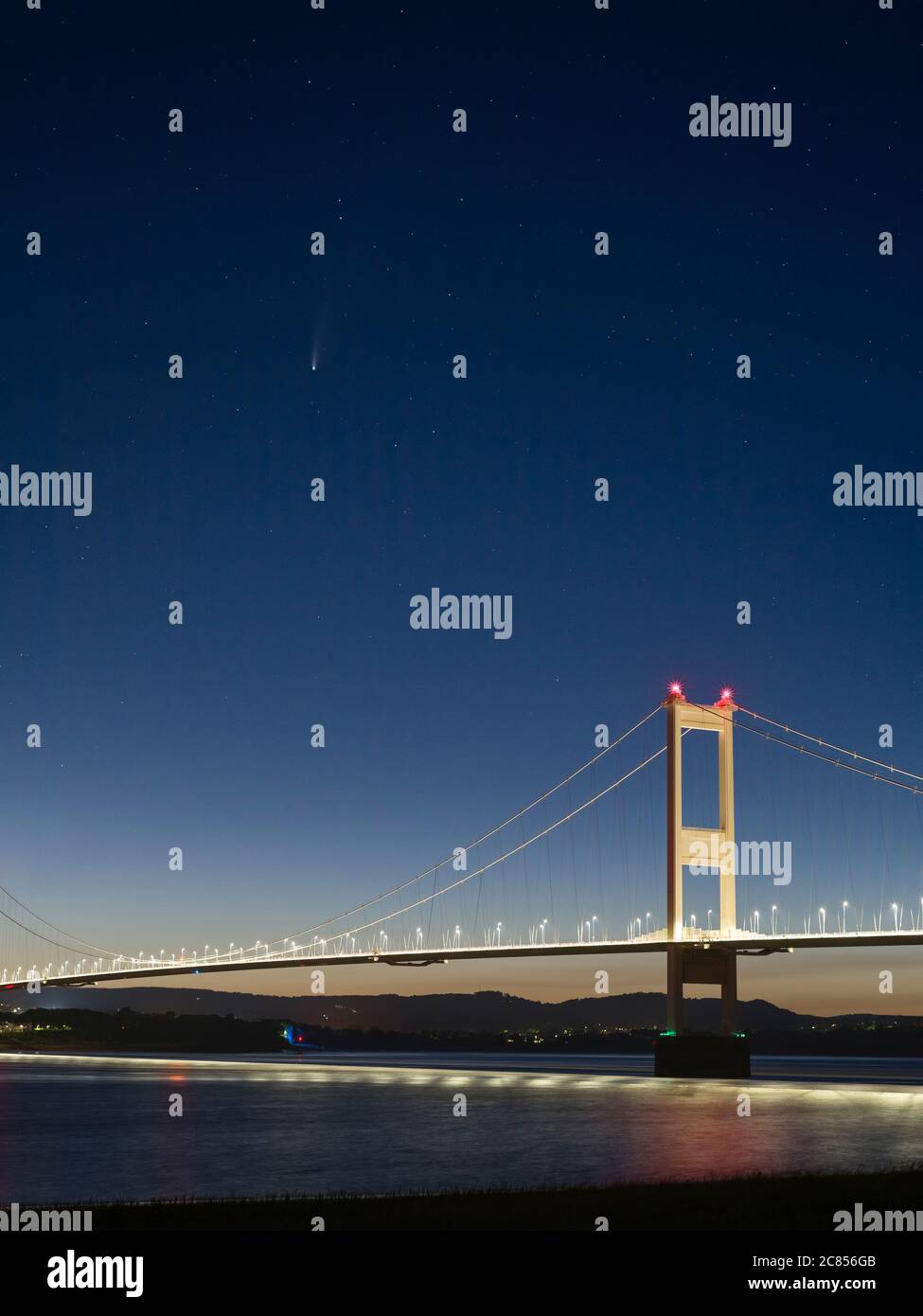 Komet C/2020 F3 Neowise über die Severn Bridge zwischen England und Wales bei Dämmerung im Juli 2020 vom Ufer des Severn in Aust, Gloucestershire, England aus gesehen. Stockfoto