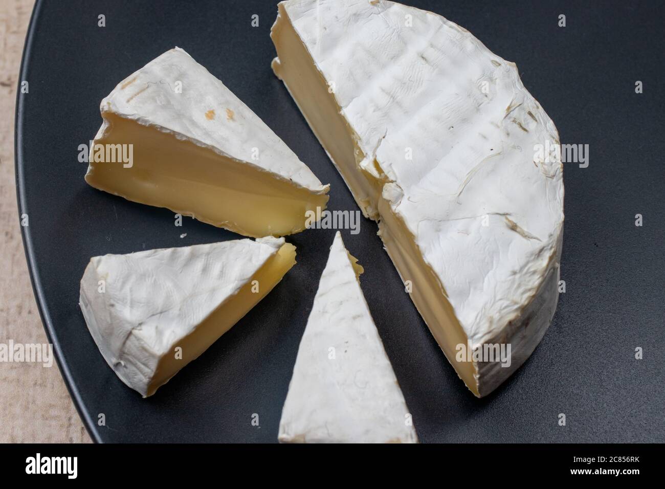 Camembert ist ein weicher französischer Elitekäse mit einer Kruste aus weißem Schimmel. Aus Kuhmilch hergestellt. Stockfoto
