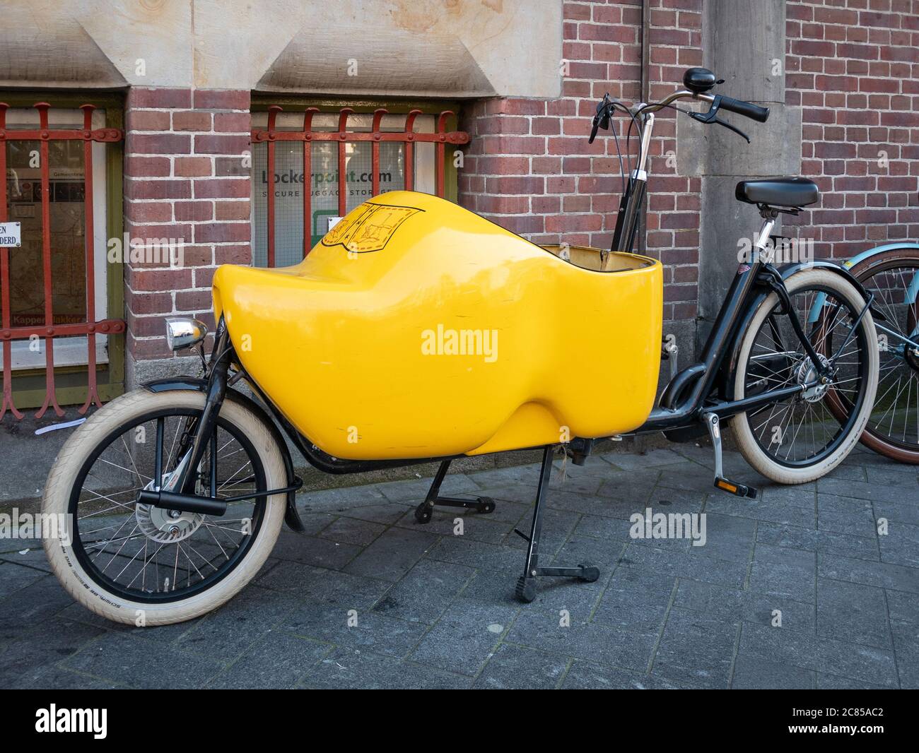 Amsterdam, Niederlande - Oktober 15 2018: Ein Fahrrad in Amsterdam in Form eines gelben Clog-Schuhs geparkt. Stockfoto