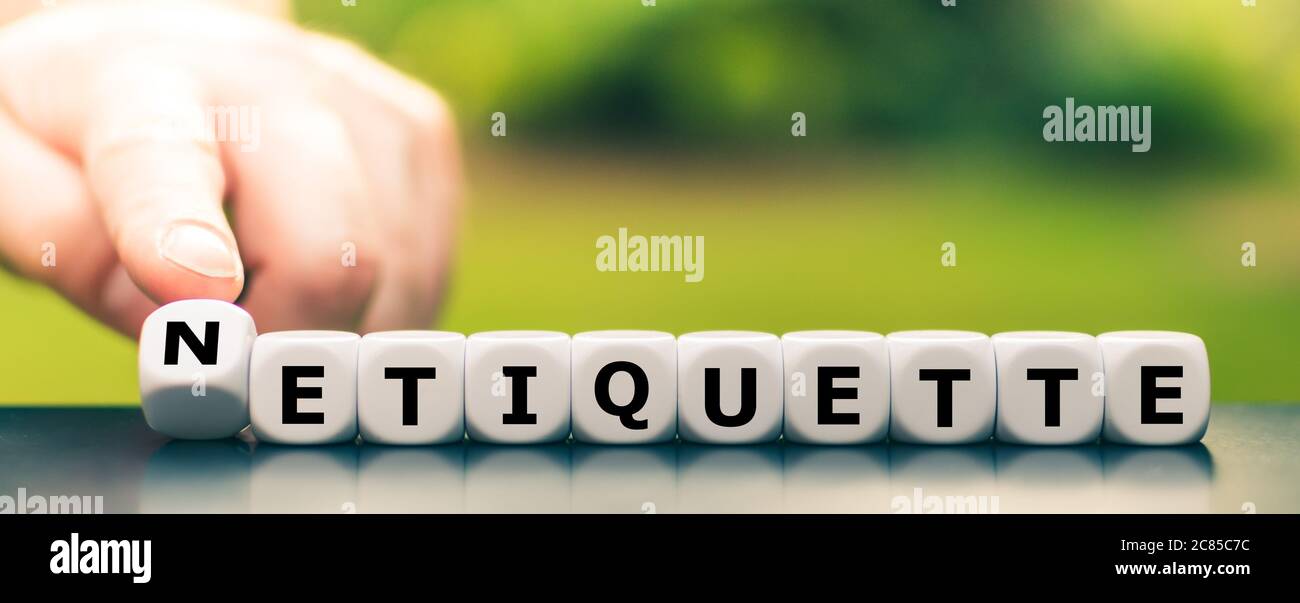 Hand dreht Würfel und ändert das Wort Etikette zu Netiquette. Stockfoto