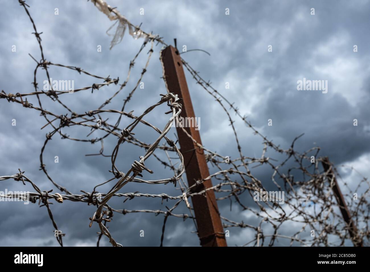 Hässlich Alter Stacheldraht auf EINEM Zaun mit einem bedeckten Himmel und Copy Space Stockfoto