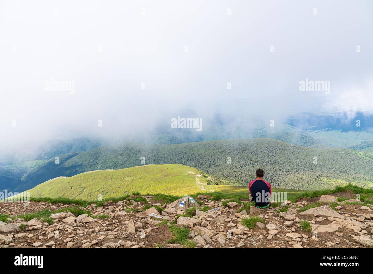 Junger Mann Wanderer beobachten die schöne nachdenkliche verträumte magische Berglandschaft. Zeit für Nachdenken Stockfoto