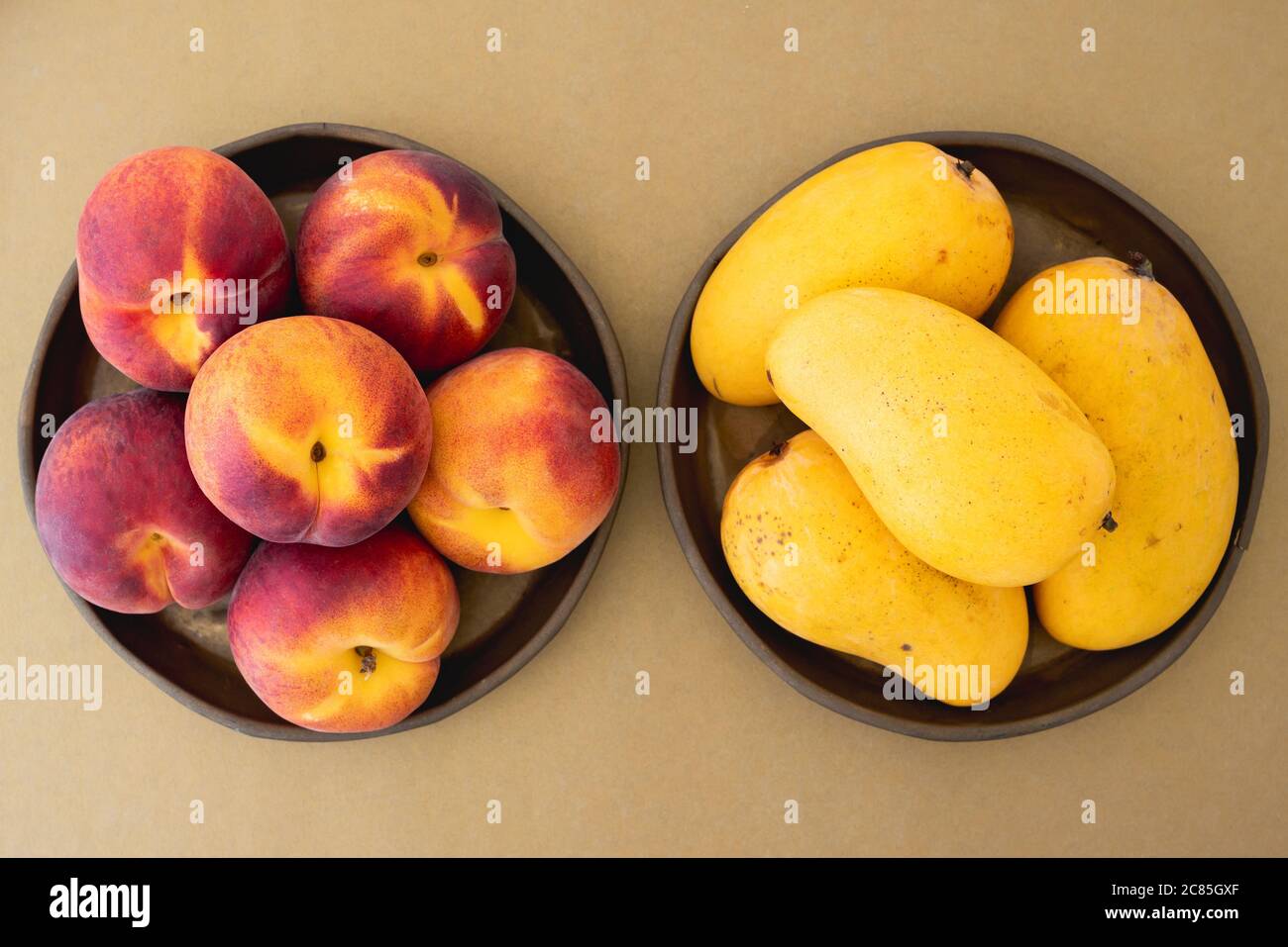 Pfirsiche und Mangos auf Platten aus der Nähe, Blick von oben Stockfoto