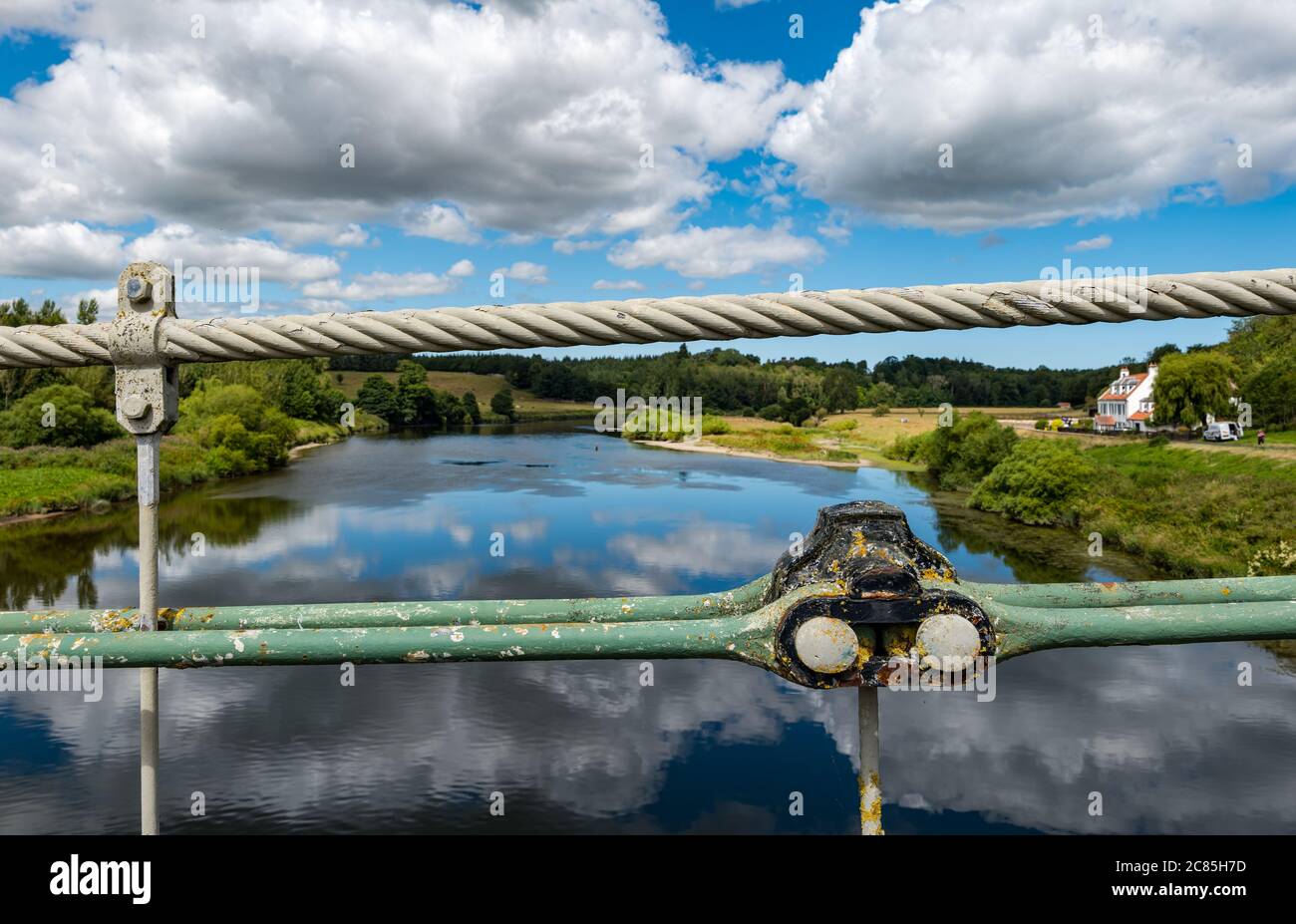 River Tweed, Englisch/Schottische Grenze, Großbritannien, 21. Juli 2020. 200 Jahre Union Bridge: Die Brücke feiert am 26. Juli ihr 200-jähriges Bestehen. Es war die erste Fahrzeugaufhängung Brücke in Großbritannien. Zur Zeit ihrer Errichtung war sie mit 137 m die längste schmiedeeiserne Hängebrücke der Welt. Es wird immer noch regelmäßig von Fußgängern, Radfahrern und Autos verwendet, aber Autos müssen es zu einer Zeit überqueren. Kabel der Brücke mit Blick auf den Fluss Tweed an der Gewerkschaftsgrenze Stockfoto