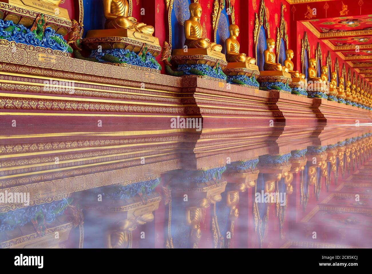 Viele Buddha-Statuen der Meditation sind in Reihen auf dem Korridor des Bang Tong Tempels aufgestellt. Provinz Krabi, Thailand Stockfoto