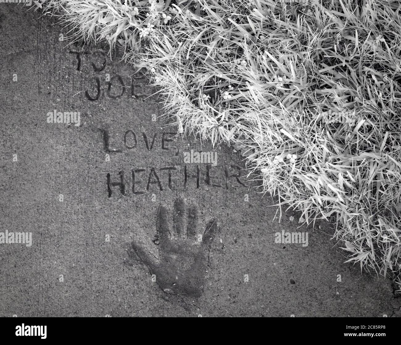 Eine Botschaft der Liebe und des Handdrucks, die dauerhaft in einen Zementsteig eingeschrieben ist. Stockfoto