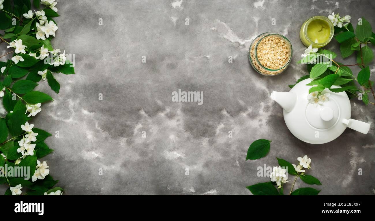 Weiße Teekanne, trockener Kräutertee, jasminblüte, flache schwarze weiße  Marmorplatte. Tea Time top view Vorlage lange Web-Banner Stockfotografie -  Alamy