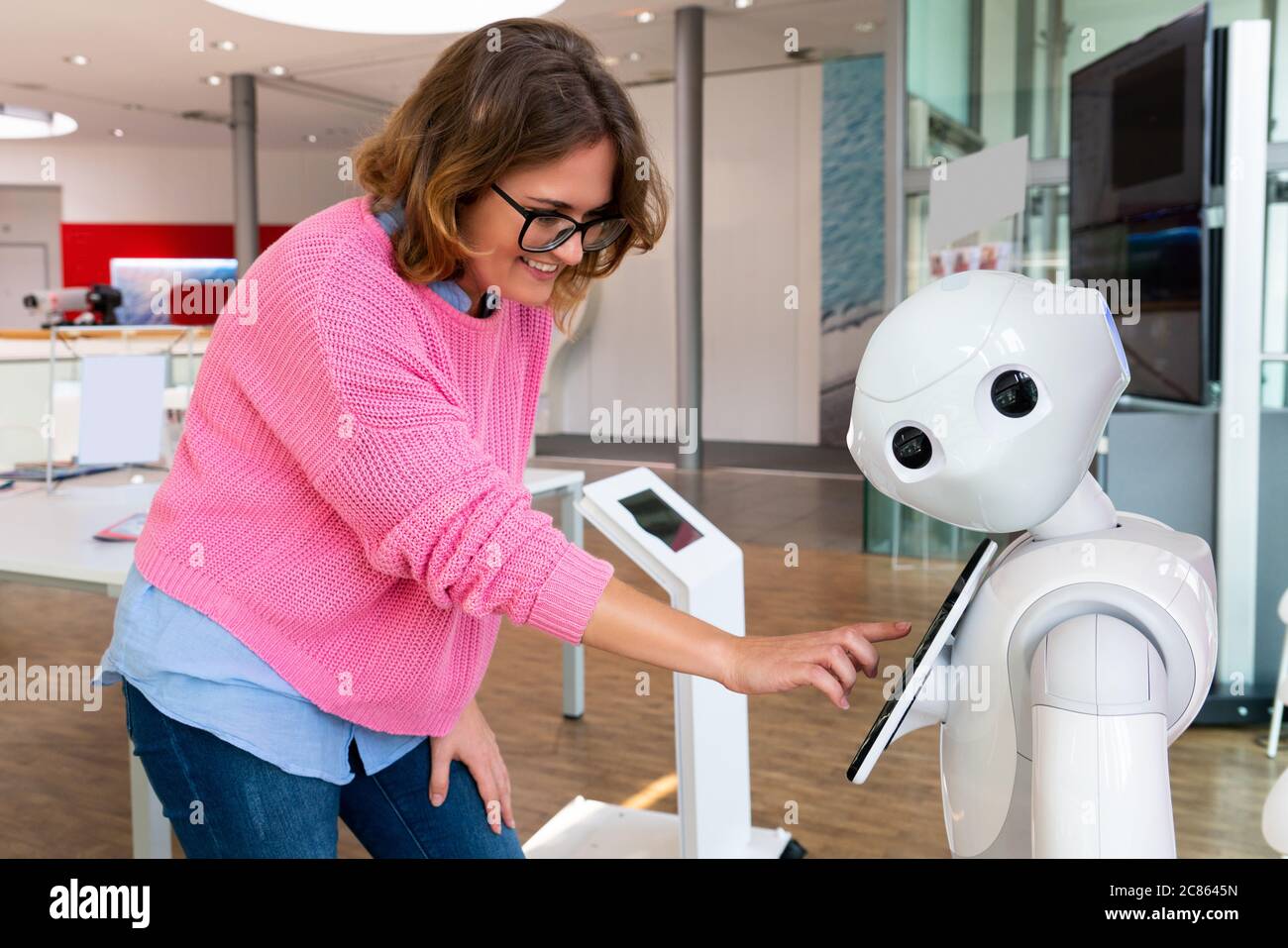 Eine Frau kommuniziert mit einem Roboter Berater Stockfoto