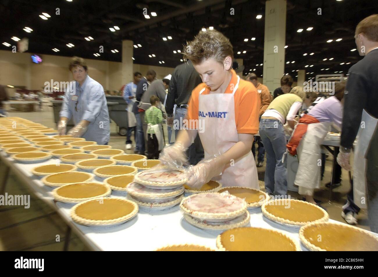 San Antonio, Texas USA, 24. November 2005: Teen Volunteer packt Kürbiskuchen beim jährlichen Raul Jiminez Thanksgiving Dinner aus, bei dem über 25.000 Mahlzeiten am Thanksgiving Day für ältere Menschen, Obdachlose, Arme und Vertriebene aus Südtexas serviert werden. Die Veranstaltung, die vom verstorbenen Restaurantbesitzer Raul Jiminez ins Leben gerufen wurde, findet im 26. Jahr statt. November 2005 ©Bob Daemmrich Stockfoto