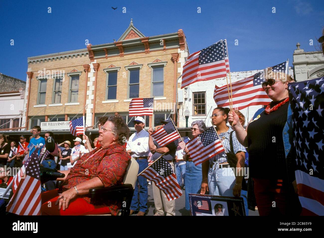 Georgetown, Texas, USA, April 2003: Die amerikanische Flagge wehende Menschenmenge nimmt an der „Support the Trupps“-Kundgebung in der Innenstadt während des Krieges im Irak Teil. ©Bob Daemmrich Stockfoto Georgetown, Texas, USA, April 2003: Die amerikanische Flagge wehende Menschenmenge nimmt an der „Support the Trupps“-Kundgebung in der Innenstadt während des Krieges im Irak Teil. ©Bob Daemmrich Stockfoto