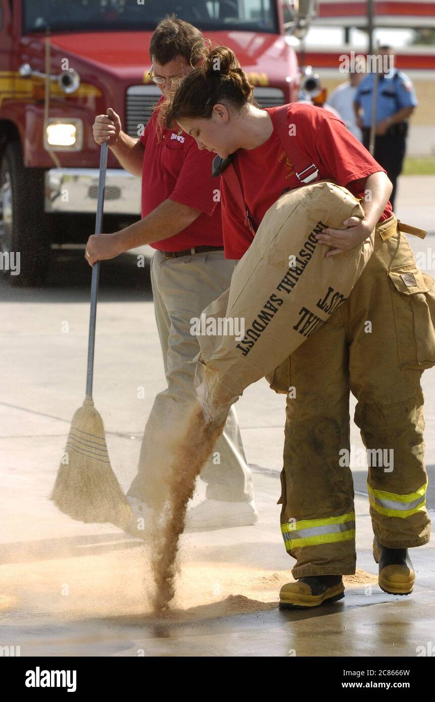 Angleton, Texas, USA, 24. September 2005: Feuerwehrleute verwenden ein industrielles Granulat-Absorptionsmittel, um eine durch den starken Wind des Hurrikans Rita im Südosten von Texas beschädigte Gaspumpe zu reinigen. ©Bob Daemmrich Stockfoto