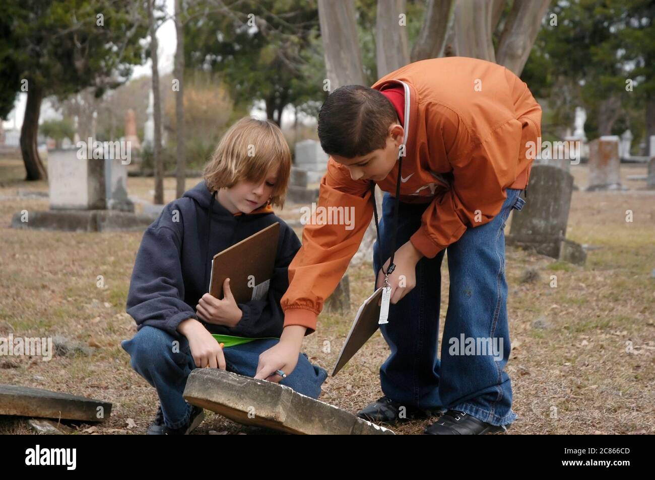 Anglo und hispanische 6. Klasse Mittelschuljungen auf einer Feldreise zum örtlichen Friedhof, um Daten von Grabsteinen für das Klassenprojekt in Austin, Texas, zu sammeln. ©Bob Daemmrich Stockfoto