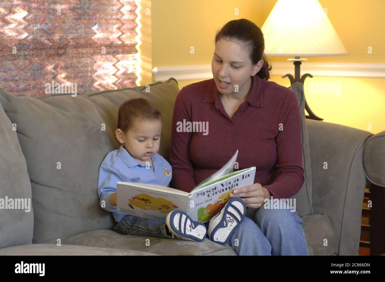 Austin, Texas, USA, Januar 2006: Die hispanische Mutter liest Anfang der 30er Jahre ihrem 22 Monate alten Sohn zu Hause ein Buch auf Spanisch vor. Modell freigegeben OK. ©Bob Daemmrich Stockfoto