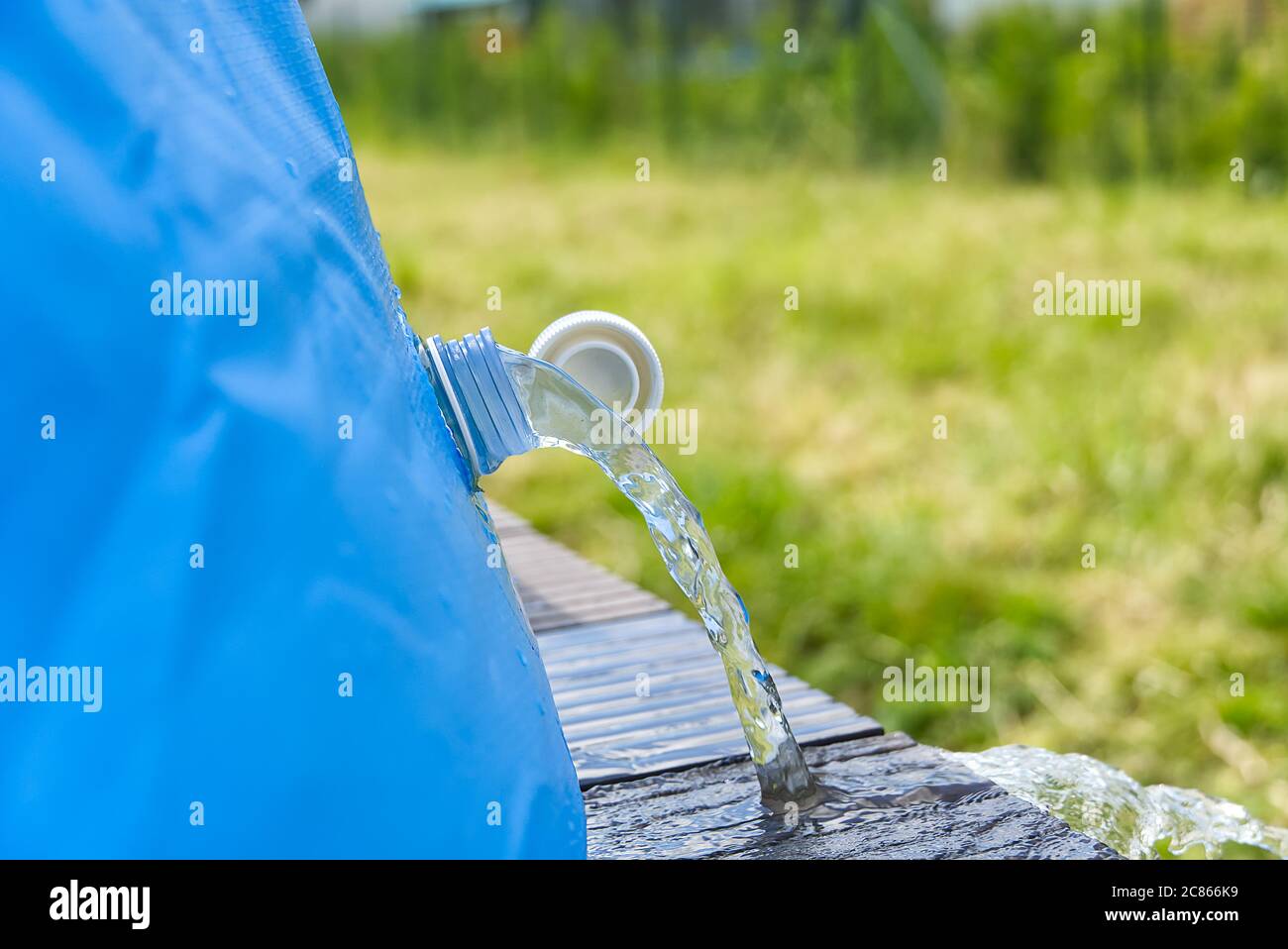 Abfluss von Wasser aus einem aufblasbaren Pool. Wasserfluss aus dem Rohr. Wasserwechsel im Sommerpool auf der Terrasse. Stockfoto