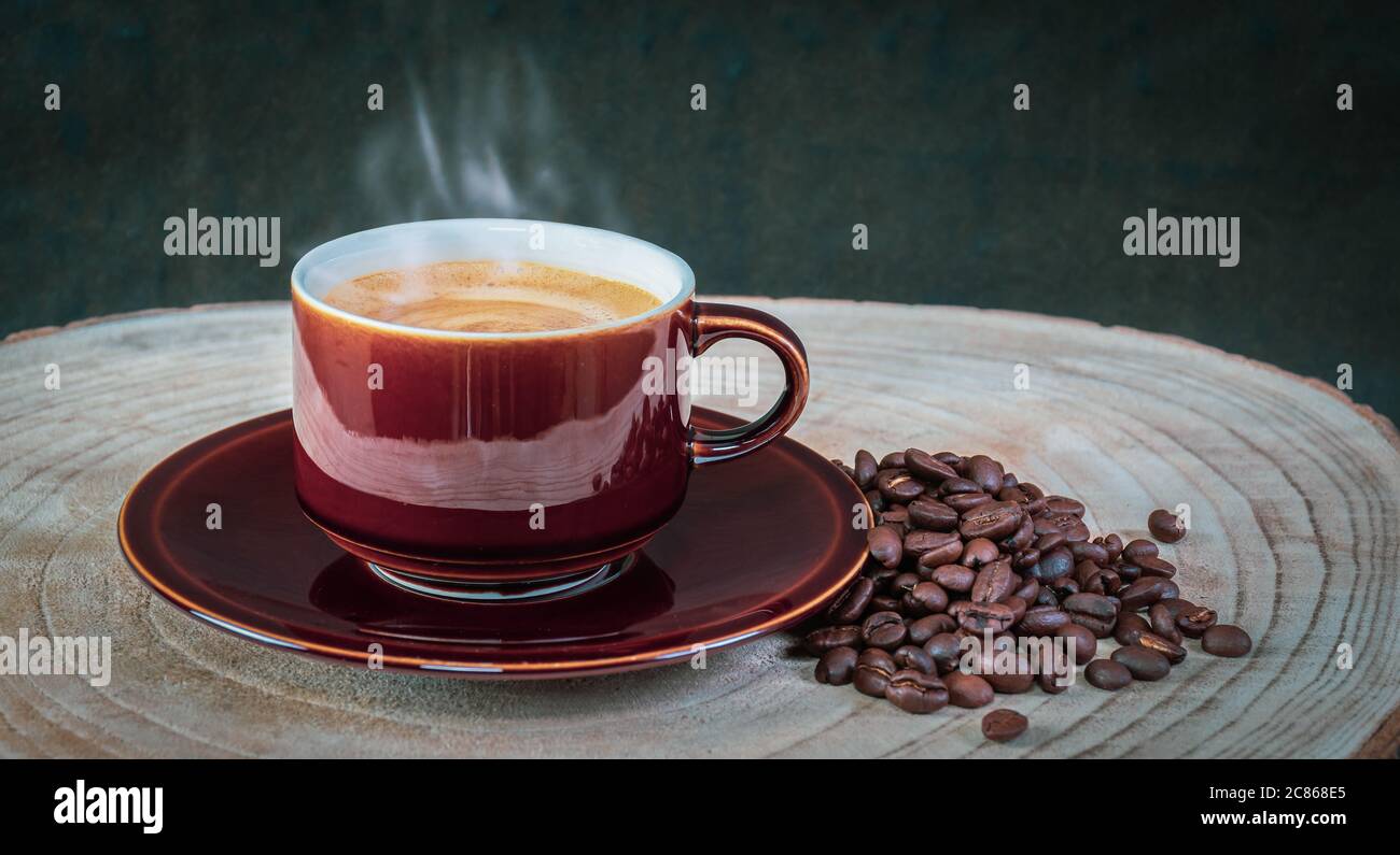 Köstlicher heißer, schaumiger Kaffee in einer braunen, glänzenden Tasse. Stockfoto