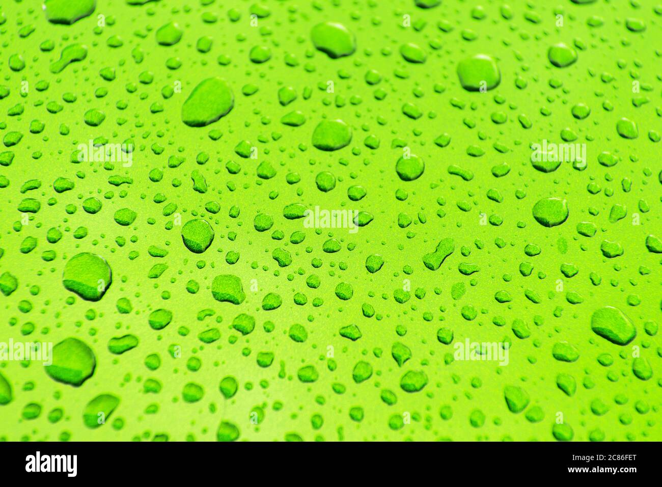 Sauber und hell Grün Auto Karosserie Farbe bedeckt von Auto Waschen Wasser Tropfen Nahaufnahme Hintergrund. Thema Automobilindustrie. Stockfoto